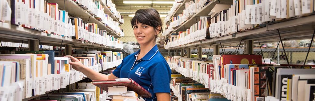 Goodwill employee sorting books and media in e-commerce department
