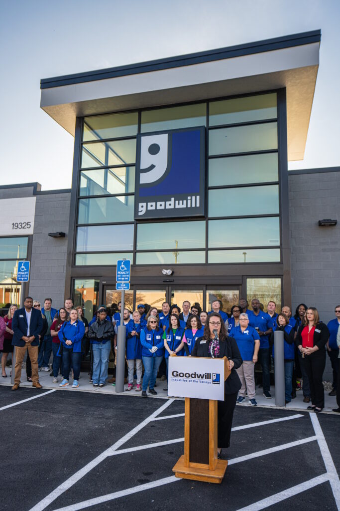 Woman speaking at the podium for the grand opening.