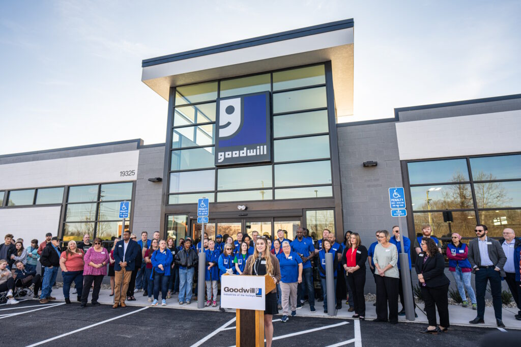 Woman speaking at the podium for the grand opening.